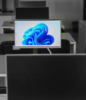 A contemporary office setup featuring computers on desks with modern flat screens.