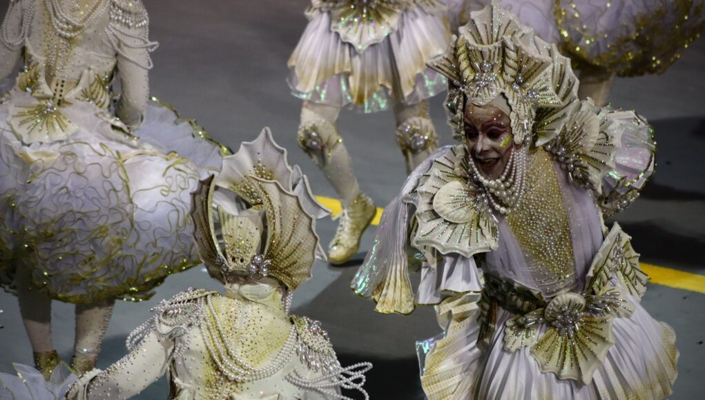 pexels-photo-15851162 Dazzling carnival performers in intricate white and gold costumes at a vibrant parade.