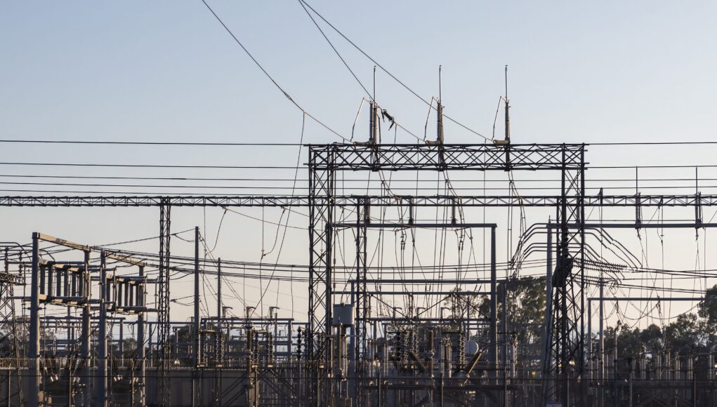 pexels-photo-18468536-1 High-voltage electrical substation with steel structures and power lines at dawn.