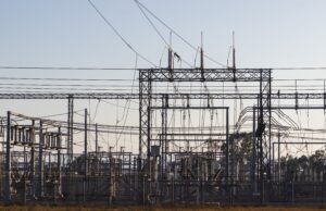 Potomac Edison Wants More Money for Reliability. Maryland Customers Should Ask What They Are Buying. High-voltage electrical substation with steel structures and power lines at dawn.