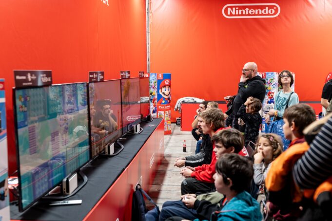 BlizzCon Sold Out. Anaheim Still Has to Prove the Convention Paid Off. A lively group enjoys gaming at a Nintendo event in Zagreb, featuring multiple screens and vibrant atmosphere.