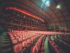 Broadway Has Become a Certification System for New Ideas Expansive interior of a modern theater with rows of empty seats and warm lighting creating an inviting atmosphere.
