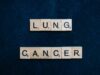 Inherited EGFR Mutation May Change How Lung-Cancer Risk Is Assessed Scrabble tiles spelling lung cancer on dark background symbolizing awareness.