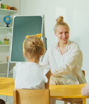 pexels-photo-8087868 Teacher engaging with preschool children in a colorful classroom setting.