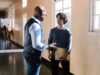 When Federal Money Disappears, the Children Still Arrive at School A high school teacher and student having a conversation in a brightly lit hallway.