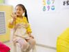 Head Start’s English-Only Proposal Could Change How Families Enter Preschool Young girl in a classroom setting learning numbers, showcasing educational activities.