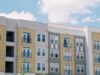 Louisville Built Housing First. Now Its Federal Application Enters a New Test Contemporary apartment building exterior with yellow and grey panels under a clear blue sky.