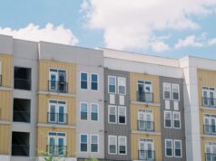 Louisville Built Housing First. Now Its Federal Application Enters a New Test Contemporary apartment building exterior with yellow and grey panels under a clear blue sky.