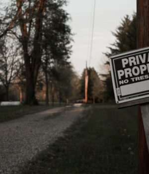 pexels-photo-12720997 A 'private property, no trespassing' sign on a wooden post along a rural road in Ohio.