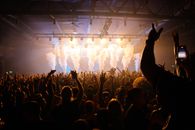 The Government Has Discovered Music Tourism. It Should Be Careful What It Preserves. Energetic crowd enjoying a concert with dynamic lighting and smoke effects in an indoor venue.