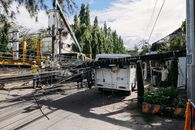 pexels-photo-34610696 Utility crew working on damaged power lines after accident on a city street with a white van involved.