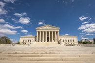 pexels-photo-36984943-1 Front view of the United States Supreme Court building on a sunny day with blue sky and clouds.