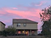 A Permit Is Not a Home: Fresno Tests the Limits of California’s Backyard-Housing Strategy A charming suburban house with a beautiful pink sunset sky, creating a serene and picturesque scene.