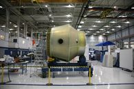 NASA Wants to Choose Science Missions Faster. The Risk Is Choosing Before the Engineering Is Ready Heavy detail of spacecraft placed on rolling platform under construction at futuristic rocket factory