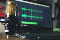 When a Stream Needs to Prove Itself Close-up of a golden microphone and laptop used for audio editing.